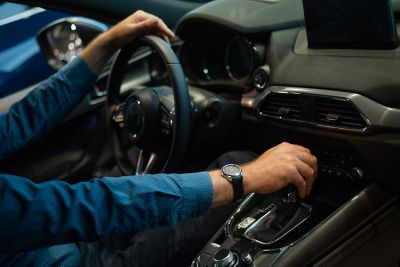 Close-up of a man's hand while shifting car transmission, Cloud Advisory Services | DXC Technology
